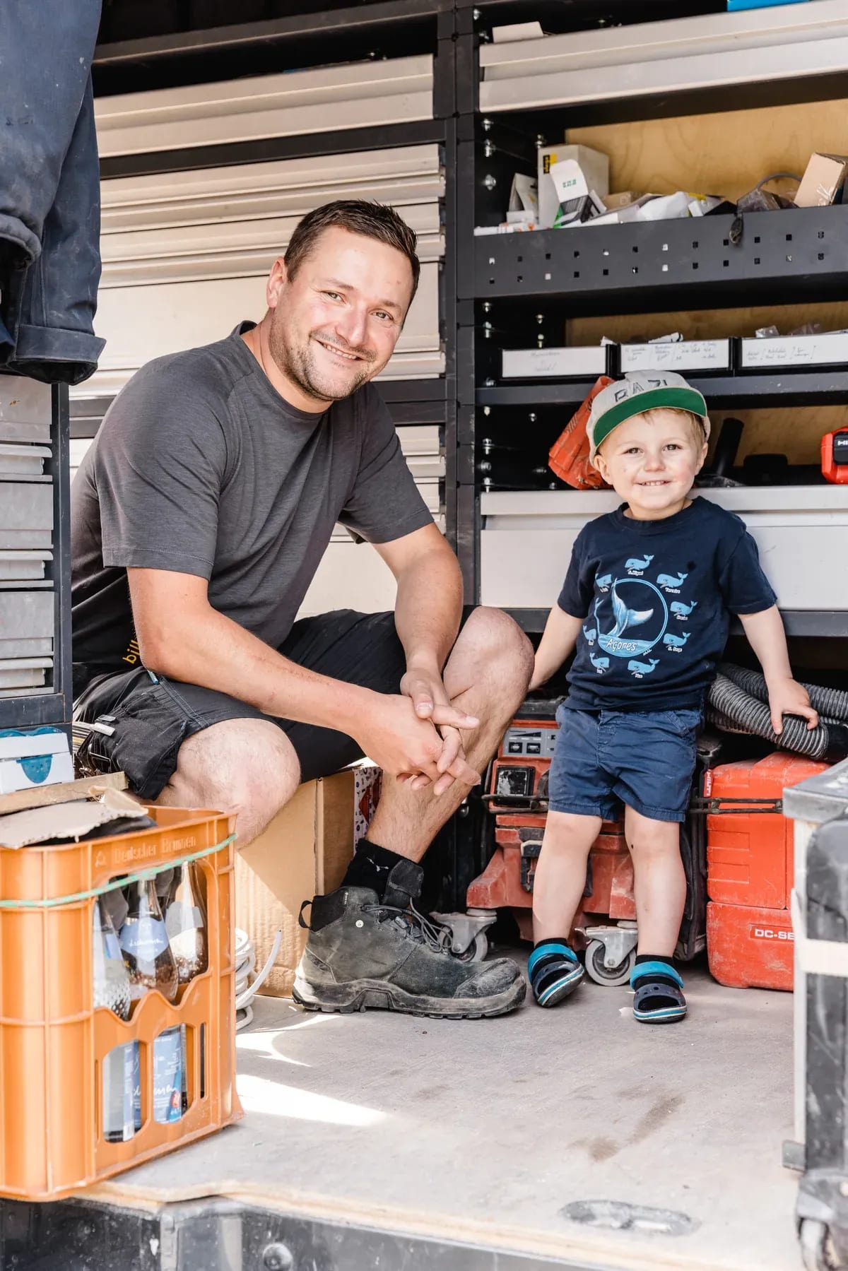 Andreas Biller mit seinem Sohn am geöffneten Firmenfahrzeug