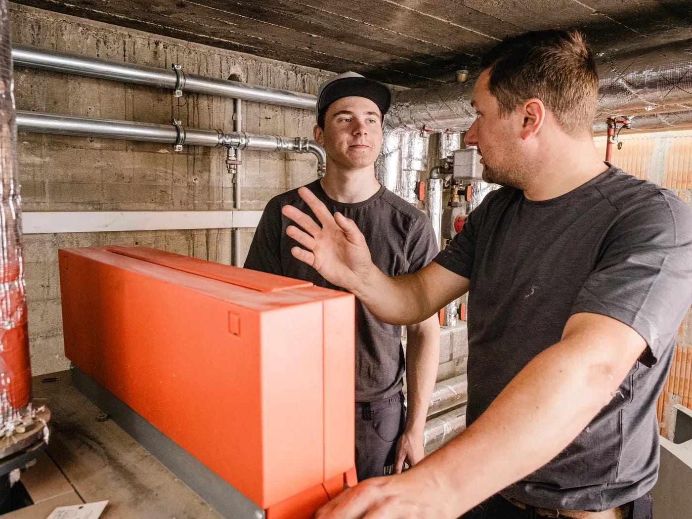 Andreas Biller erklärt seinem Auszubildenden die Technik im Heizraum