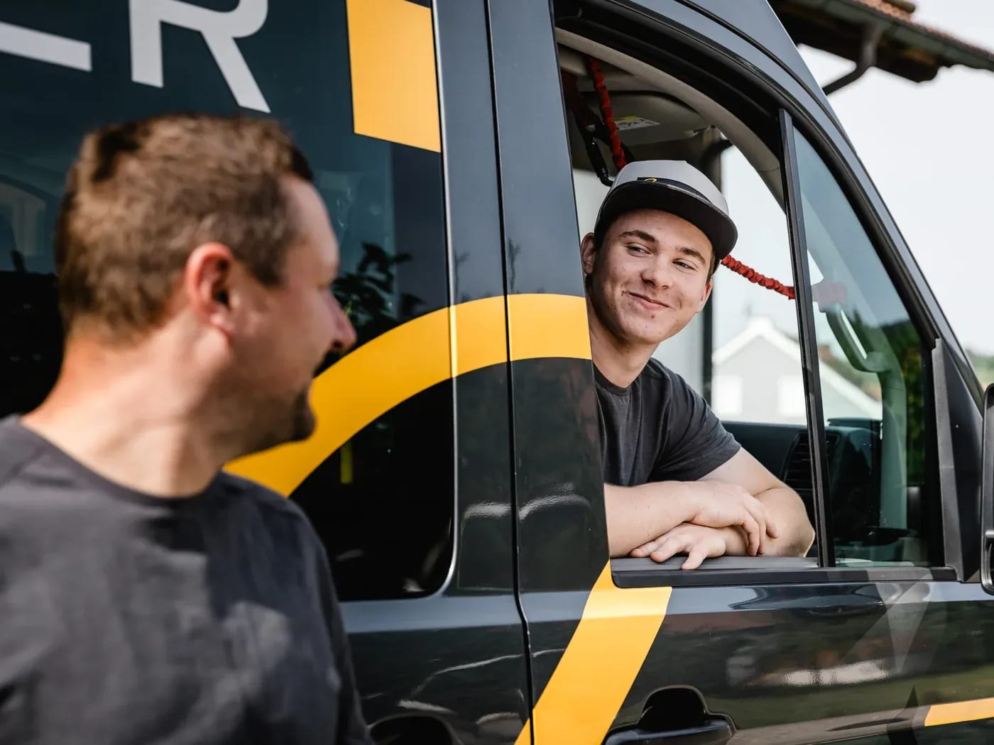 Andreas Biller im Gespräch mit einem Mitarbeiter am Firmenfahrzeug
