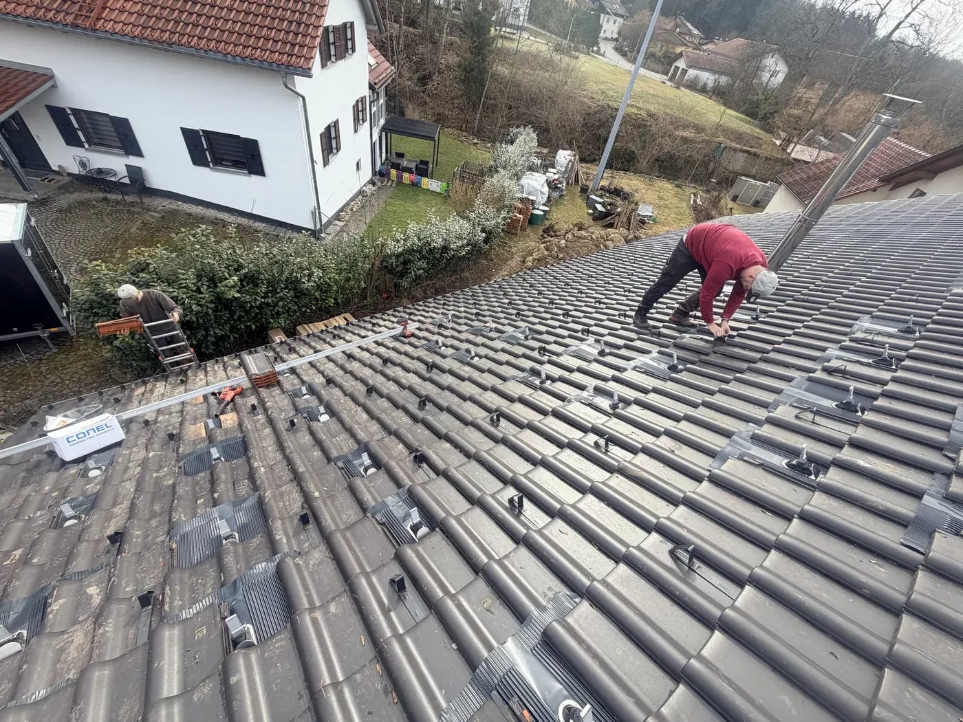 Montage einer Photovoltaikanlage: Dachhaken und Schienen auf dem Ziegeldach